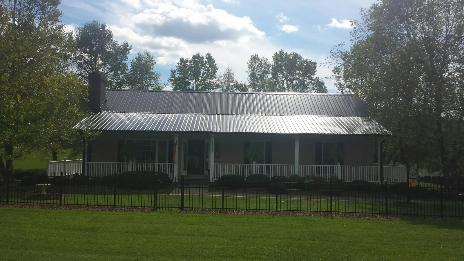 Gray metal roof on a brick ranch with a full width front porch — Gutter Guard Installation work by our crew in South El Monte